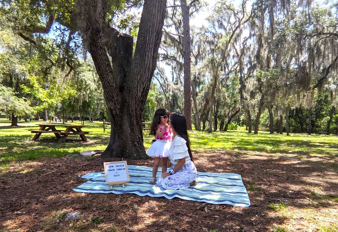 Melissa and daughter on a blanket at Mead Botanical Garden