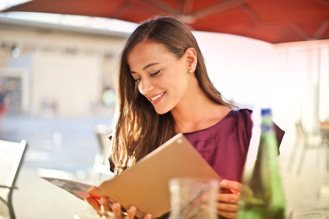 Woman smiling while reading a book