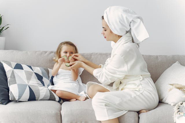 Mother and daughter putting cucumbers on eyes