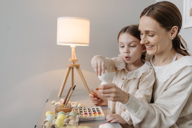 Mother and daughter painting eggs