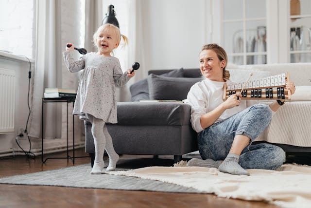 Mother playing xylophone while daughter uses maracas