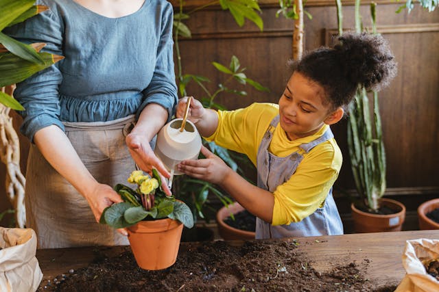 Mother and daughter watering plants