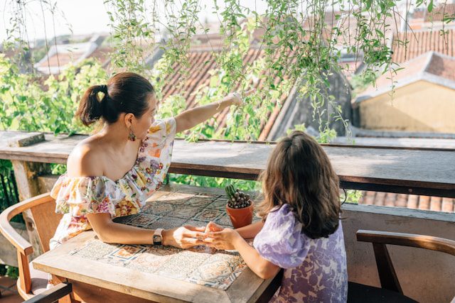 Mother and daughter sitting in the outdoor area of a restaurant 