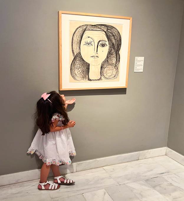 Melissa's daughter looking at a painting at the Picasso museum
