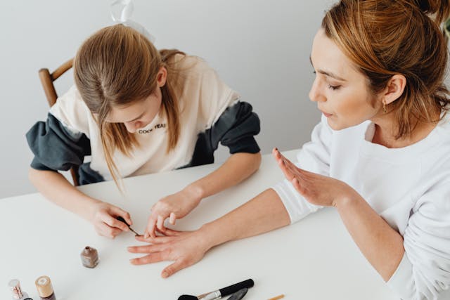 Daughter painting her mothers nails