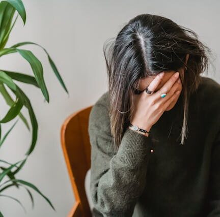 Woman covering her face with her hand