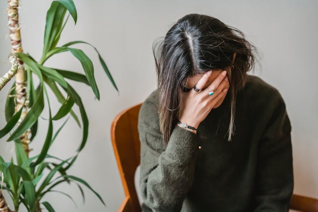 Woman covering her face with her hand