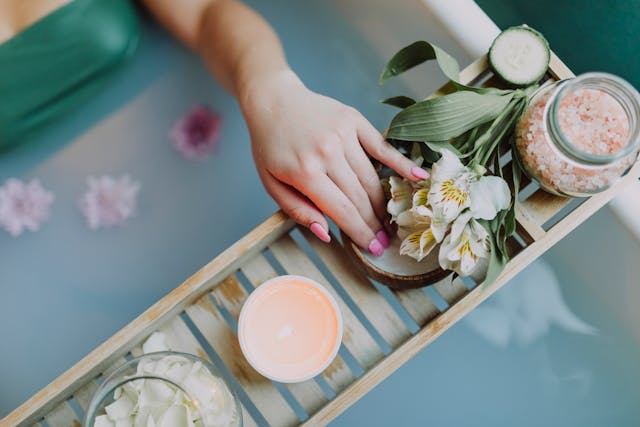 Woman in bath with candles and flowers
