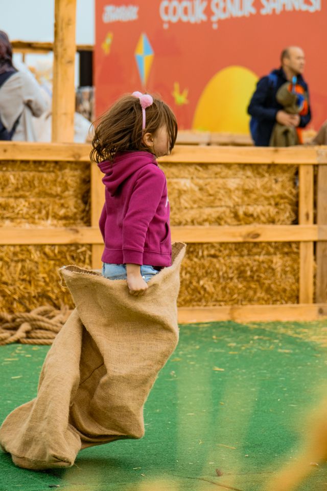 Girl competing in a potato sack race