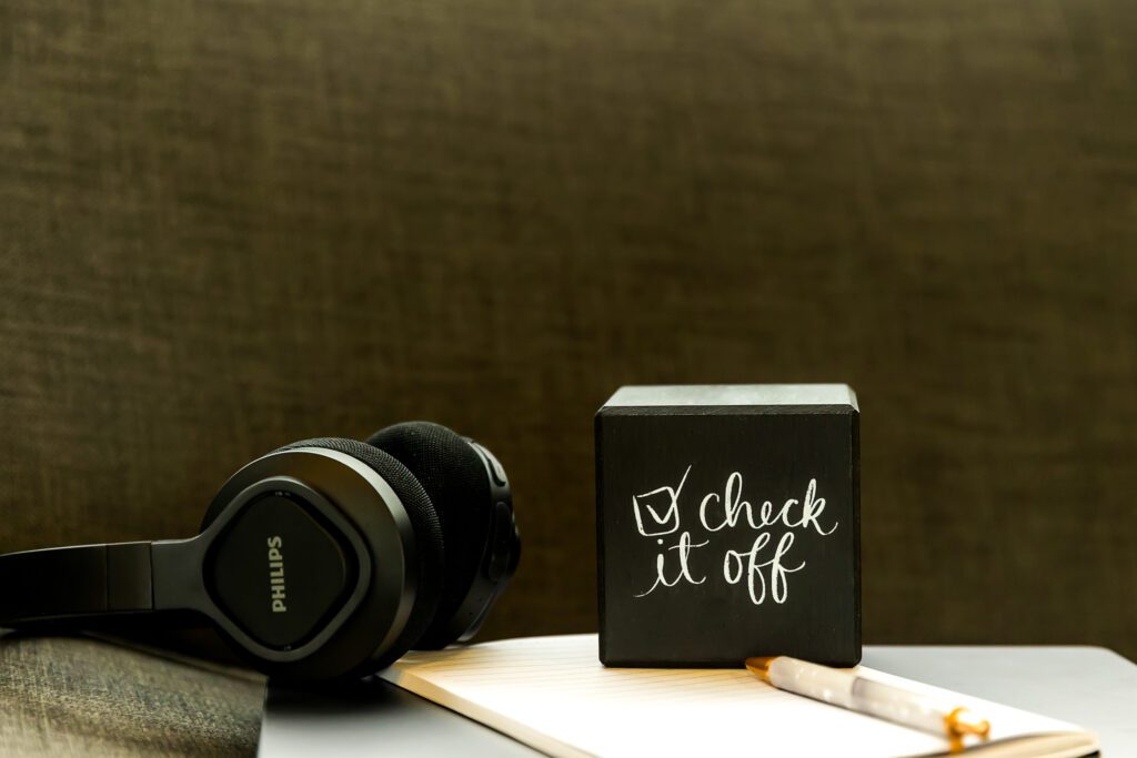 Black headphones beside a check it off quote