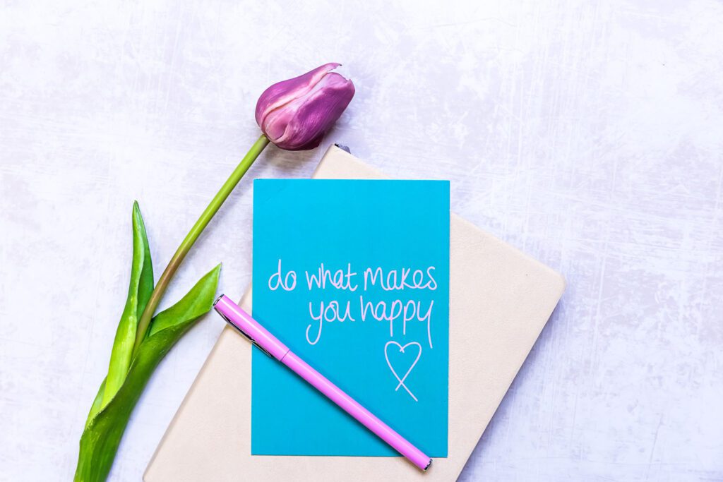 A motivational quote on a notebook and next to a tulip flower