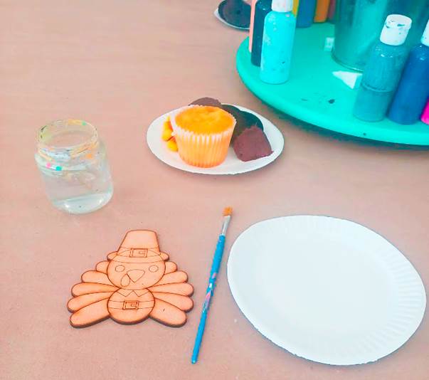 Cupcake, wooden turkey, and painting materials