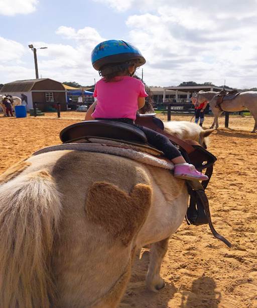 Melissa's daughter riding a horse at DreamCatcher Horse Rescue