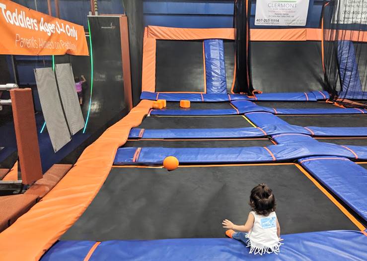 Melissa's daughter sitting in a Sky Zone trampoline