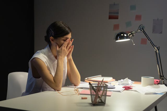 Woman with hands on face while at her desk