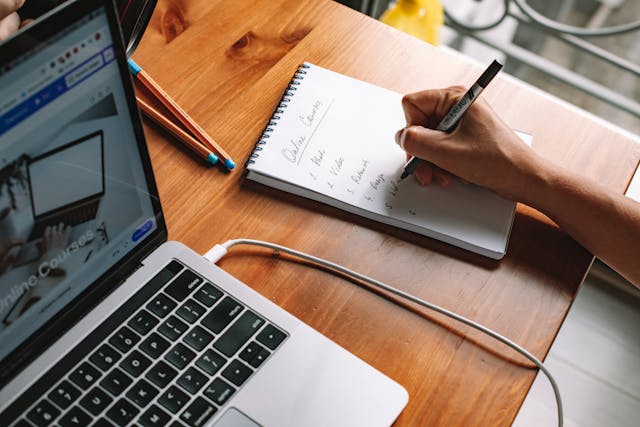 Woman taking notes from an online course