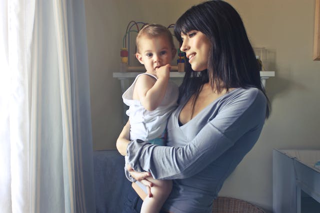 A mom holding her baby at home