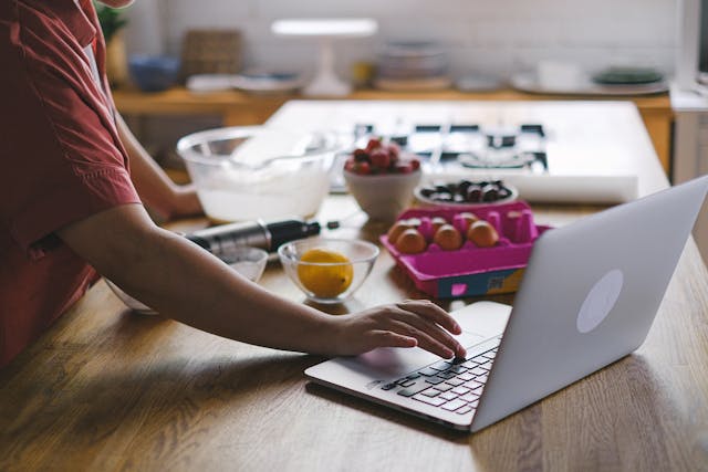 Woman searching on the computer while cooking