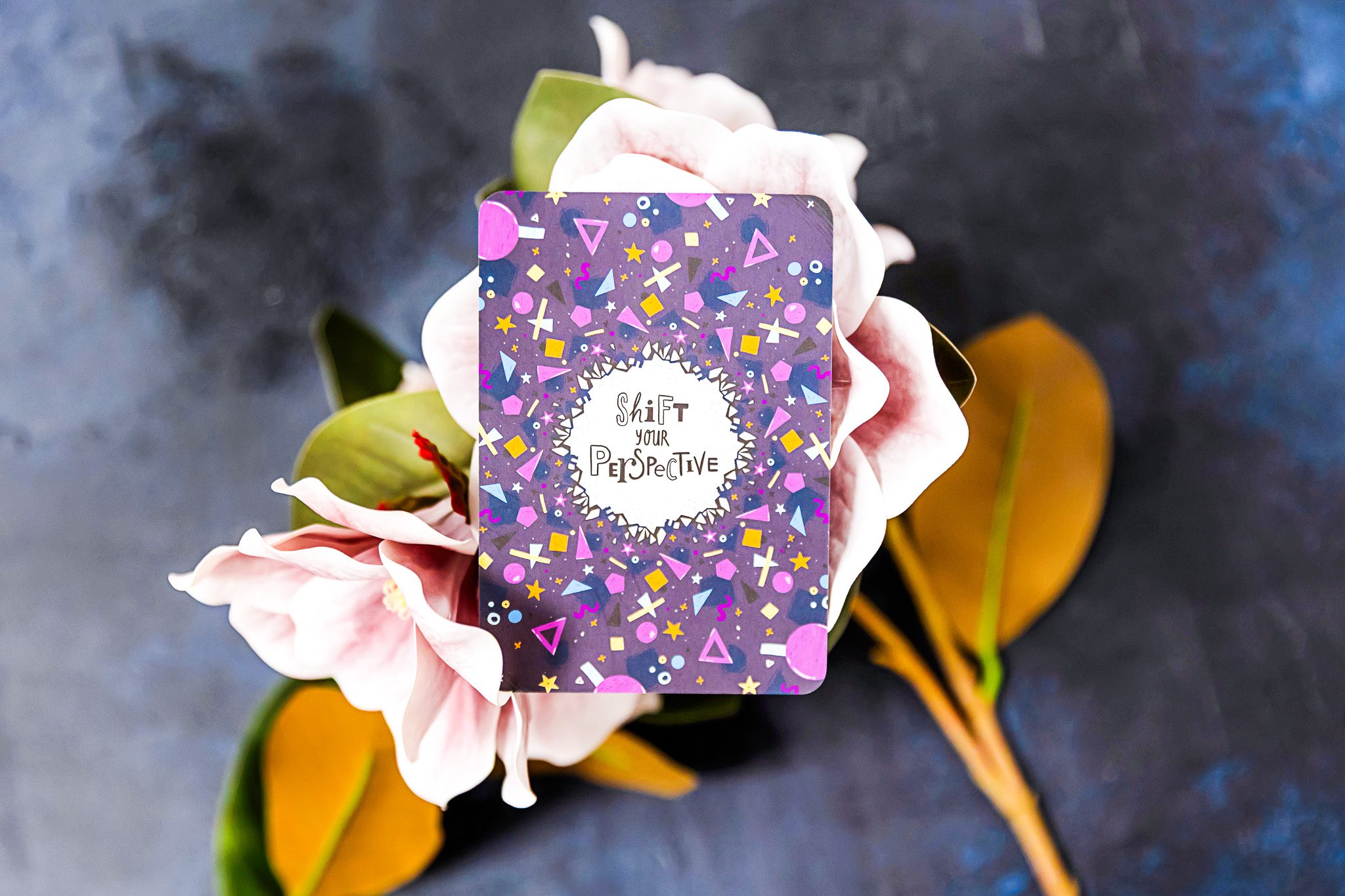 A positive quote on purple geometric shapes on pink flowers