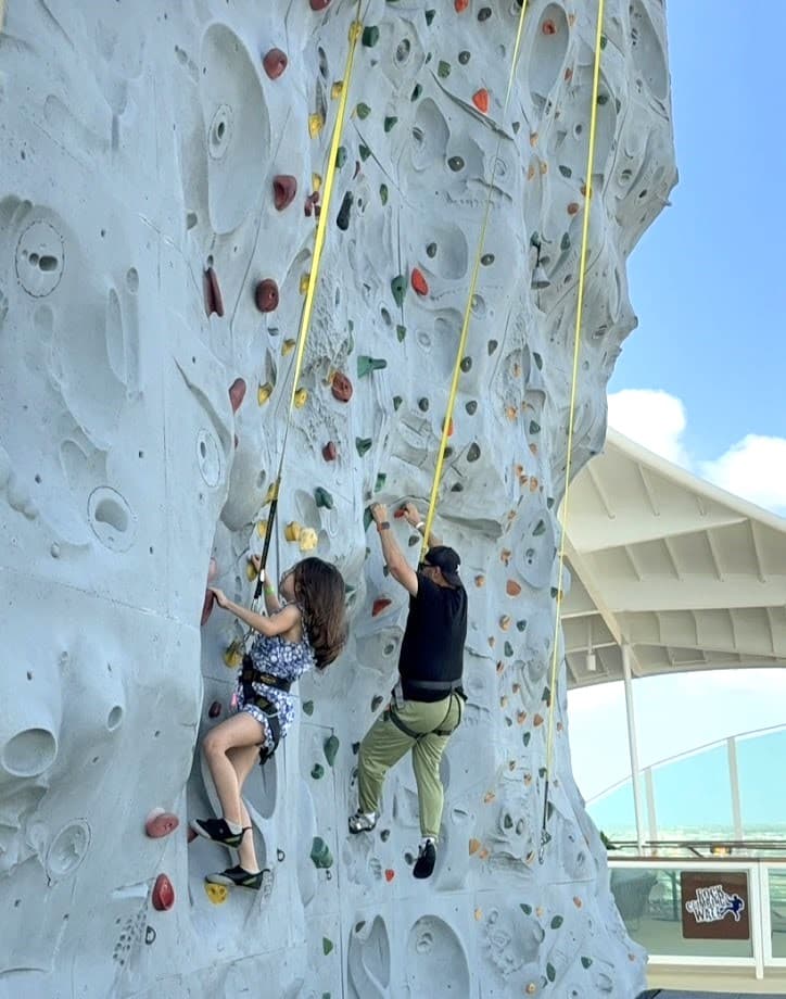 Father and daughter rock climbing on cruise