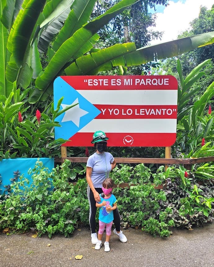 Melissa and daughter in front of a wooden flag with a message