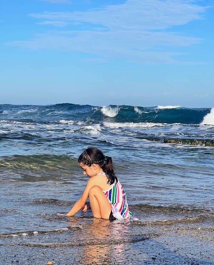 Melissa’s daughter playing in the sand at the water’s edge
