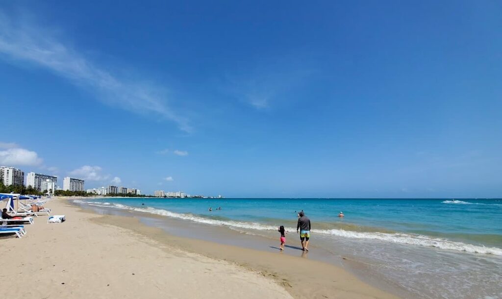 Melissa's husband and daughter walking on the beach in Isla Verde