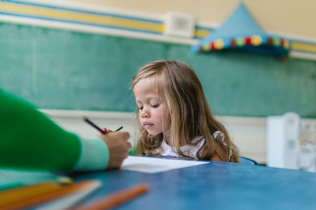 Close-up of a girl student listening to the teacher’s explanation