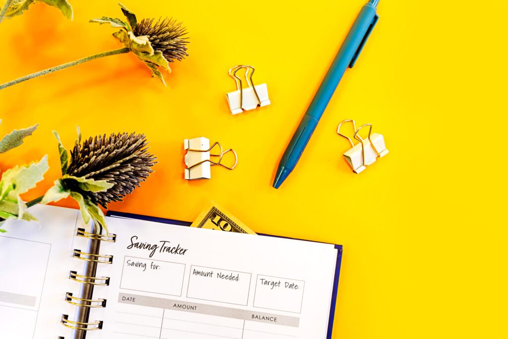 A saving tracker near a pen and clips