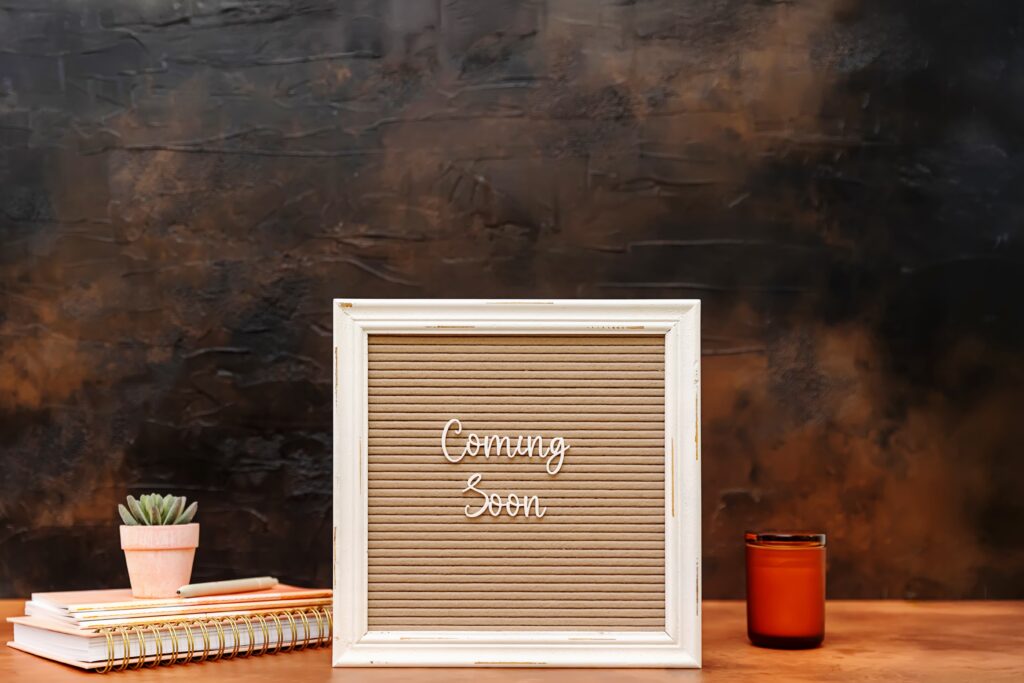 A "Coming Soon' sign next to a notebook