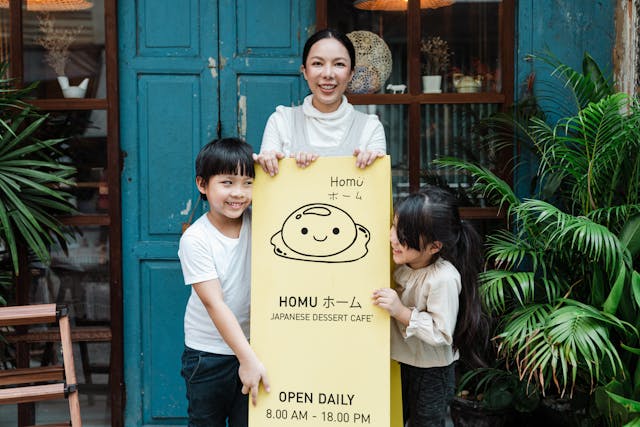 Mom and children posing by a Japanese dessert store sign