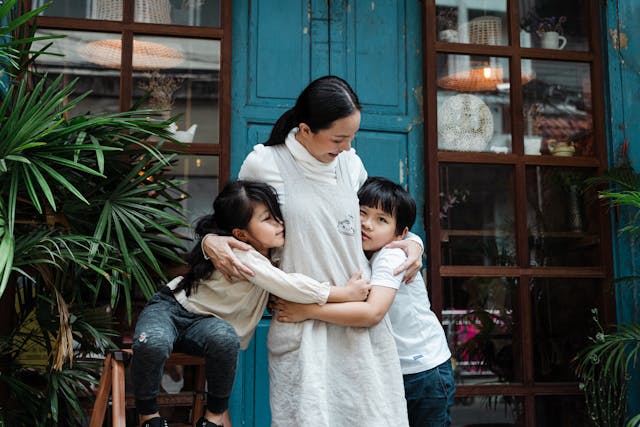 Mother hugging children