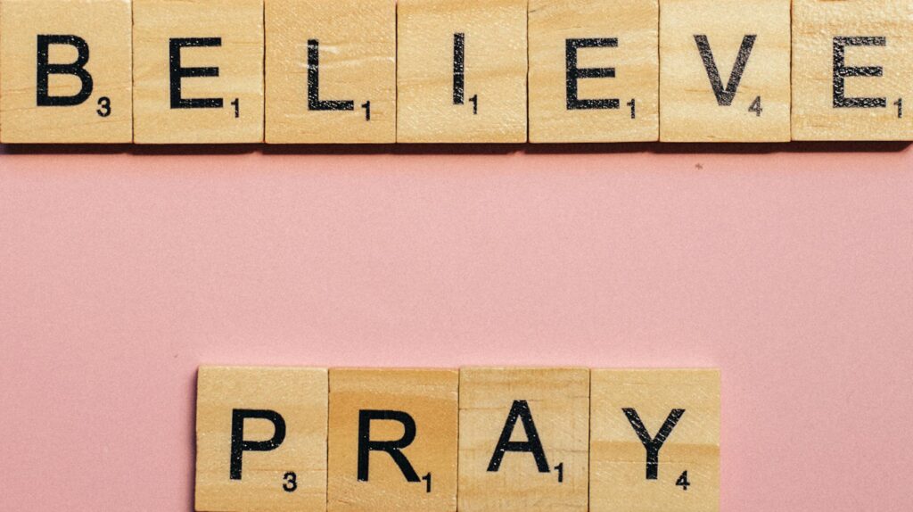 Scrabble tiles spelling the words “believe” and “pray”