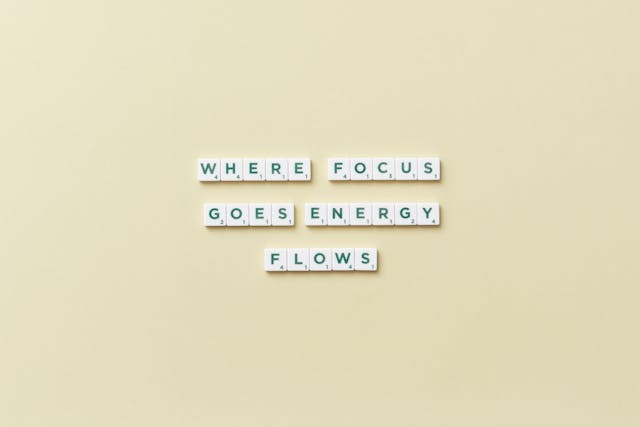 Inspirational quote “Where focus goes, energy flows” on a yellow background
