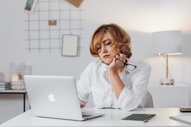 Woman thinking while using laptop