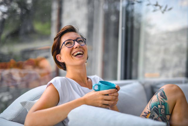Woman laughing with cup in hand