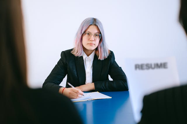 Woman in a job interview while an employer reads her resume