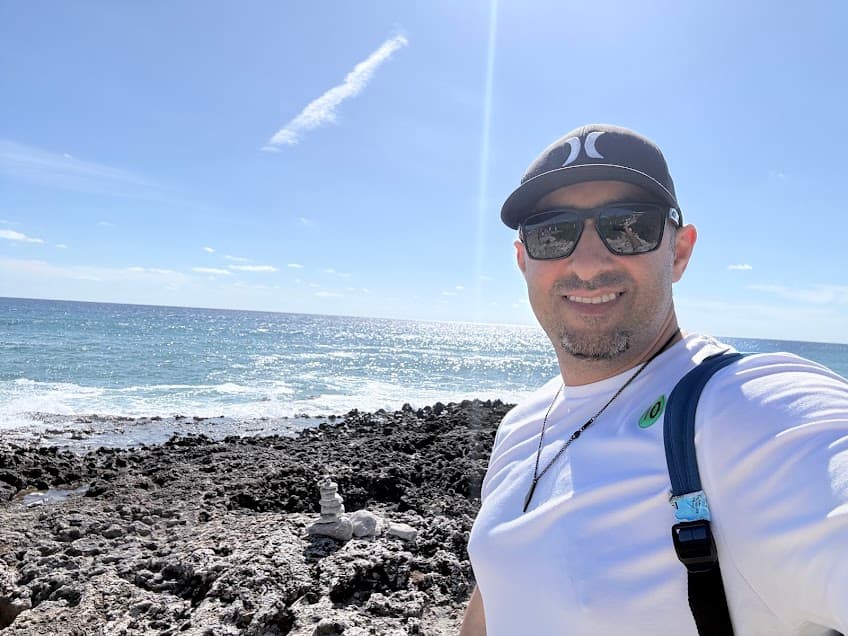 Melissa's husband posing with beach background