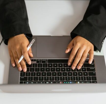 Hands typing on laptop