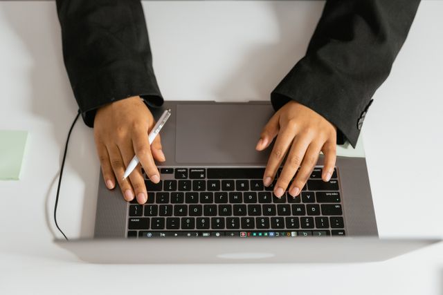 Hands typing on laptop