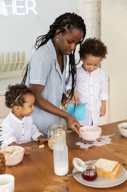 A mother helps kids clean spilled breakfast in the morning